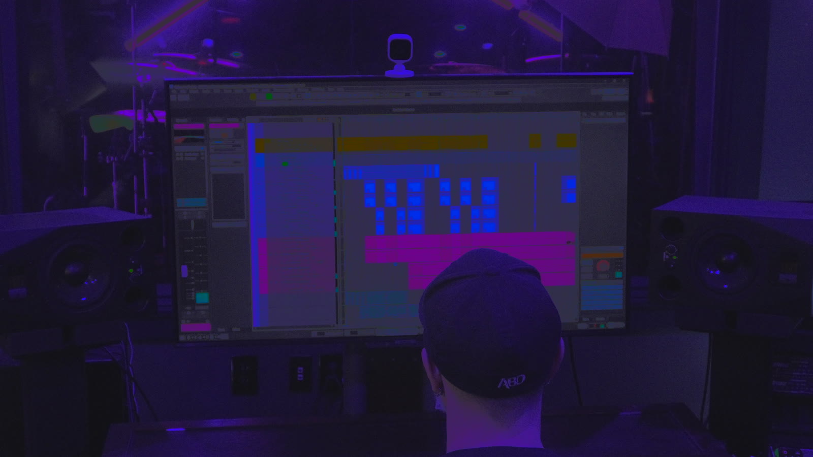 Josh Holland at his studio desk, seen from behind, with a song open on the screen